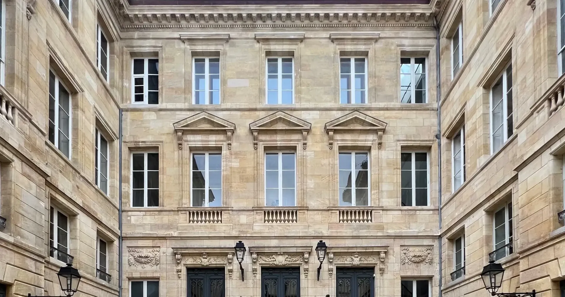 Façade en pierre de taille et fenêtres d’un hôtel particulier bordelais